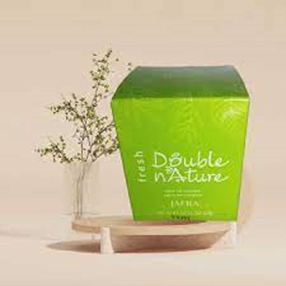 Green Double n' Nature product box on a wooden stand with a plant in the background