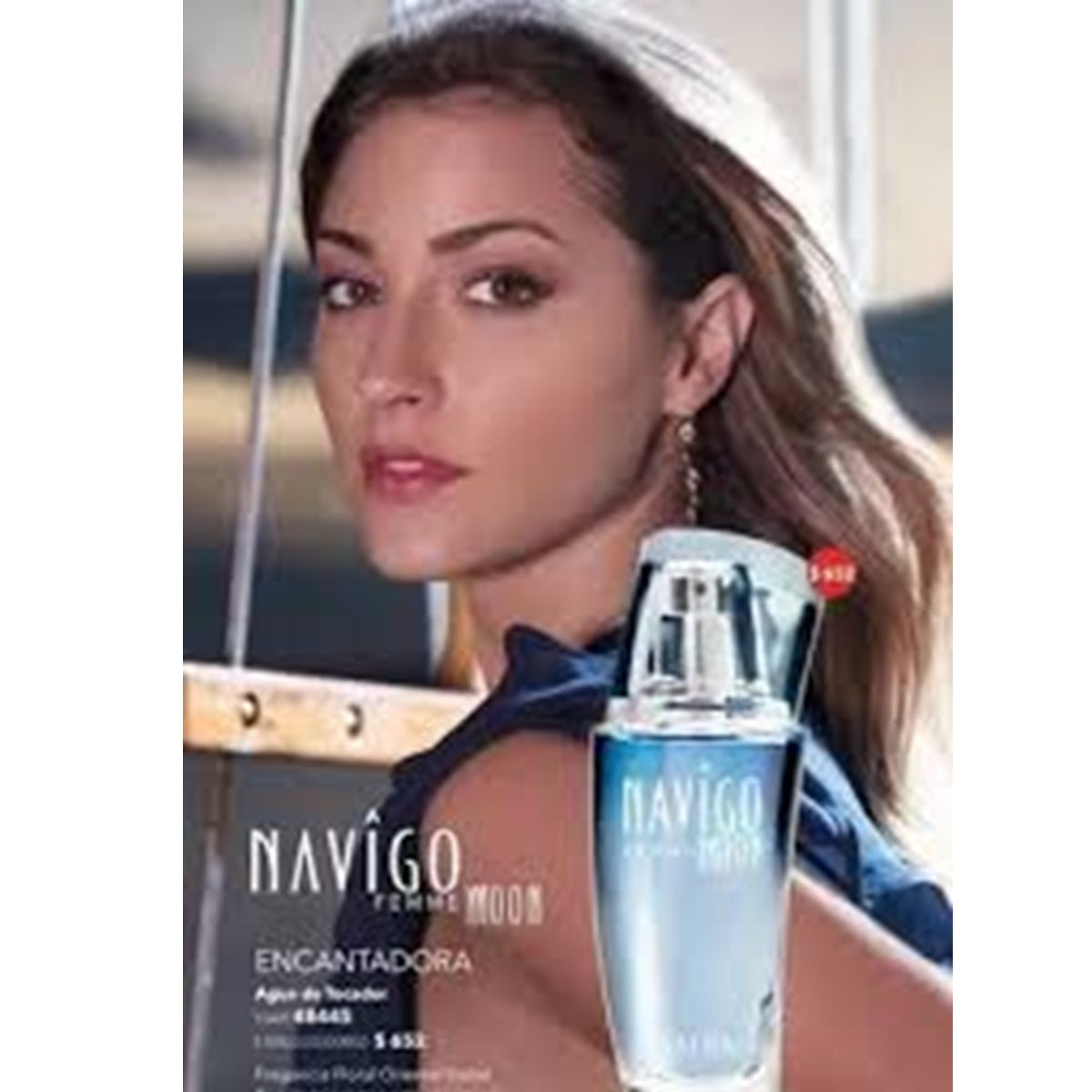 Woman holding a Navigo perfume bottle with a blurred background