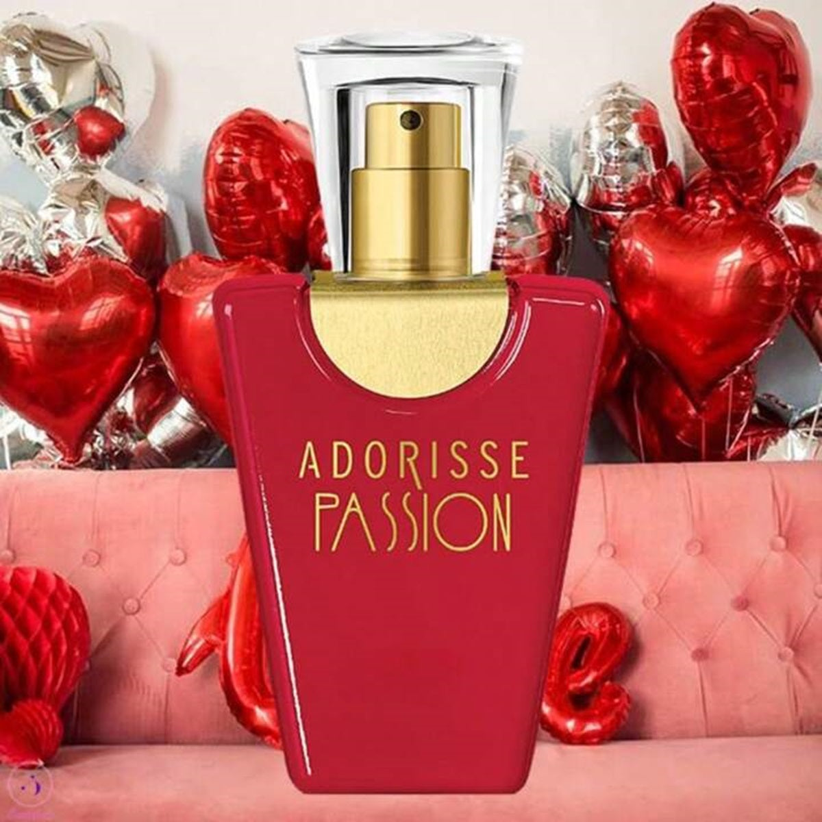 Red Adorisse Passion perfume bottle with gold cap against a pink couch and heart-shaped balloons.