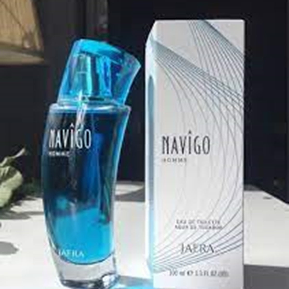 Blue perfume bottle and packaging labeled 'Navigo' on a table.