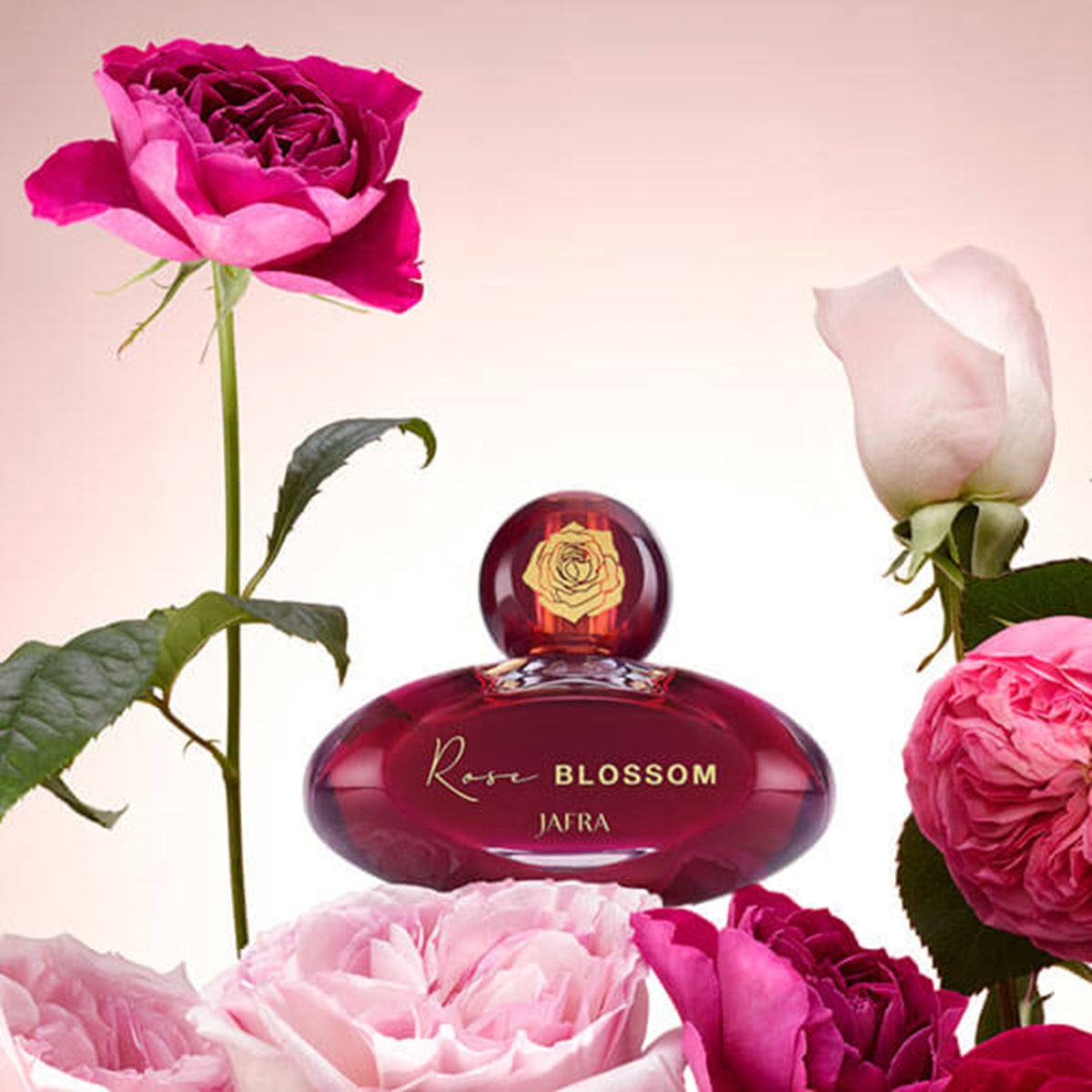 Perfume bottle labeled 'Rose Blossom' surrounded by pink roses on a light pink background