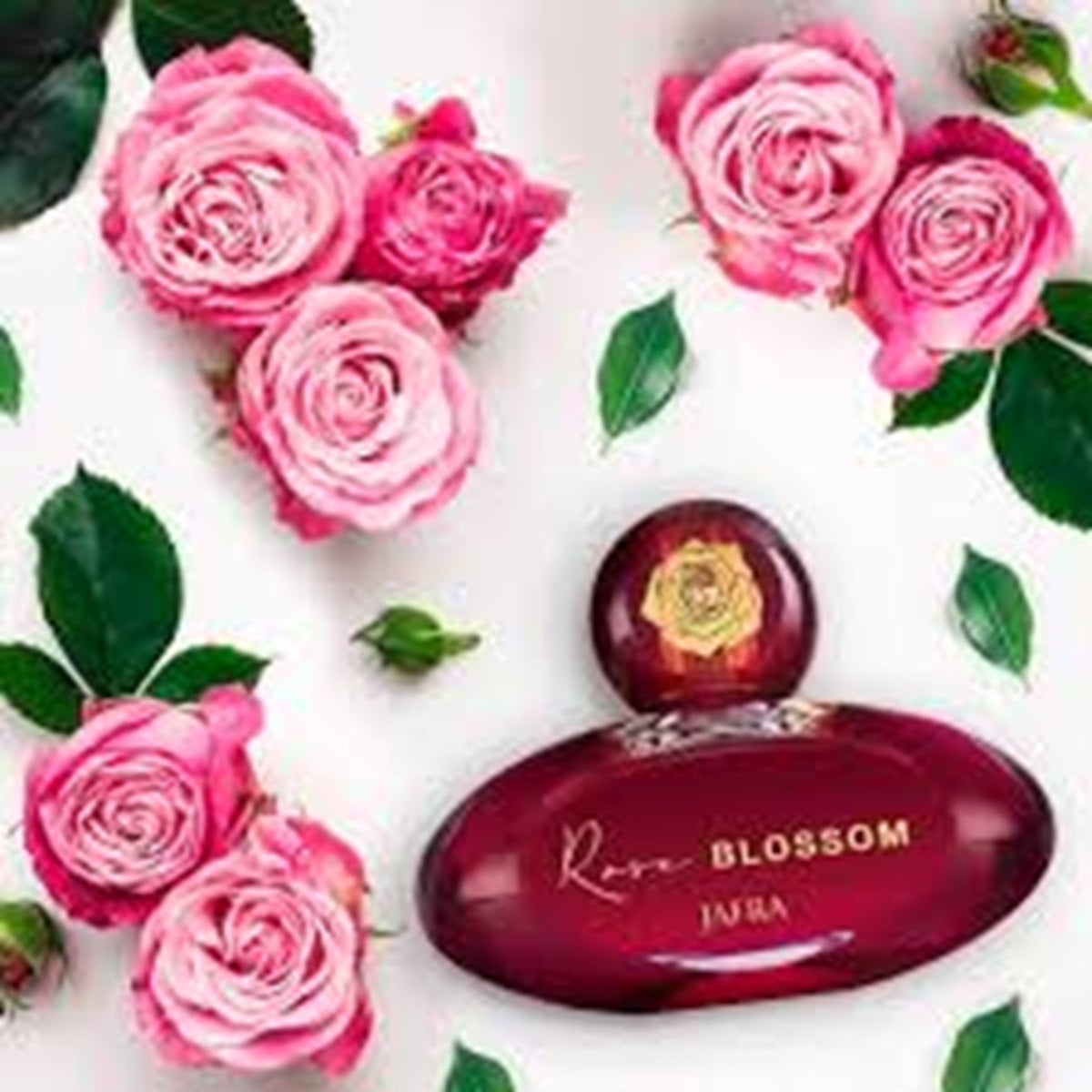 Red perfume bottle labeled 'Rose Blossom' surrounded by pink roses and green leaves on a white background