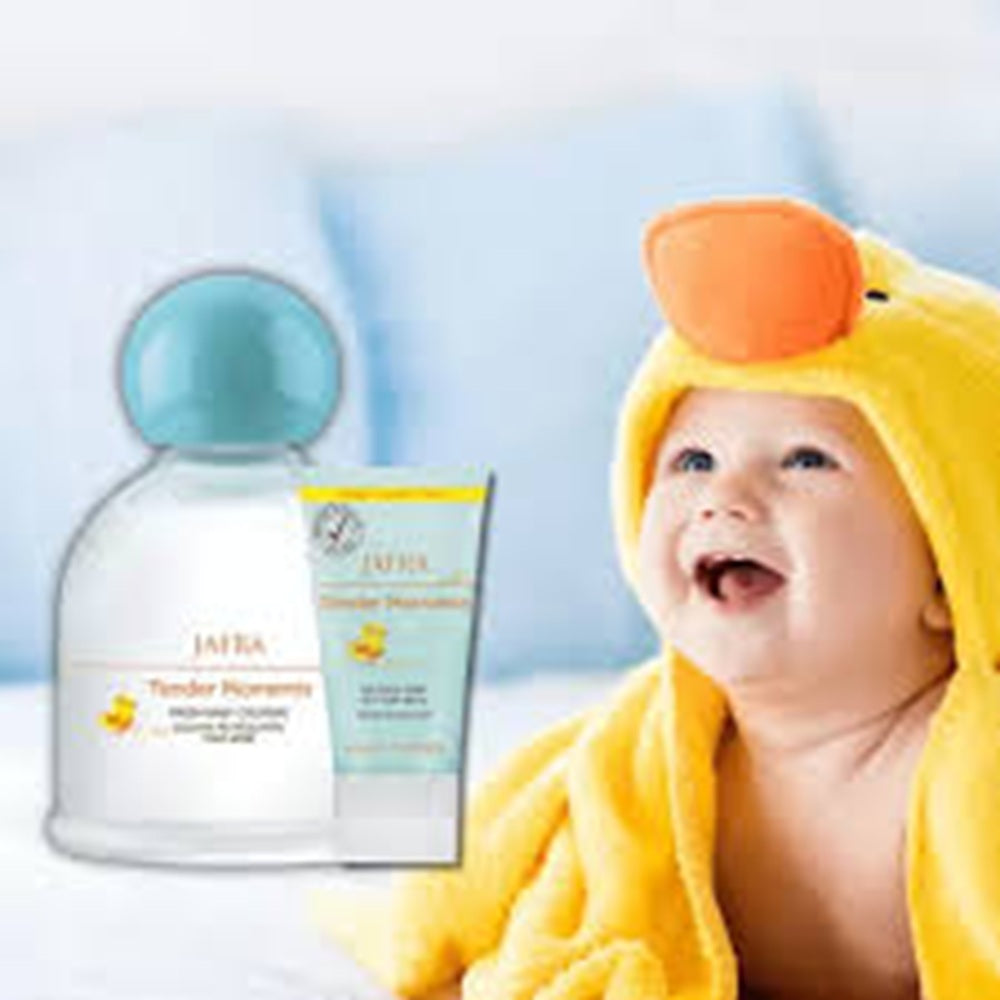 Baby in a yellow towel with skincare products on a light blue background