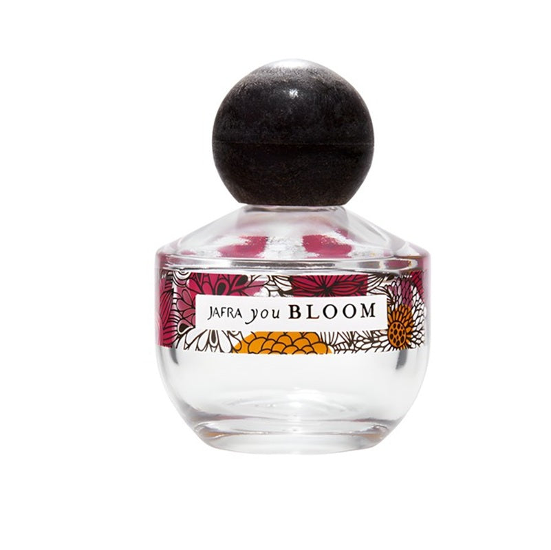 Perfume bottle with floral design and 'Jafra You Bloom' label on a white background